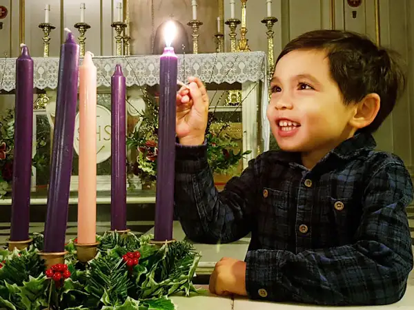 Boy lighting an advent candle